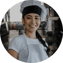 Professional chef smiling in a bustling kitchen with ChefsTemp branding visible.
