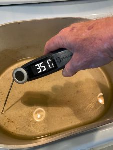 High-precision digital food thermometer measuring pan temperature with 35.1°F reading.