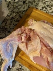 Raw chicken on a wooden cutting board ready for cooking.