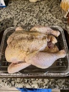 Raw whole chicken on a baking tray ready for cooking.