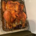 Perfectly roasted whole chicken on a grilling rack, ready to serve.