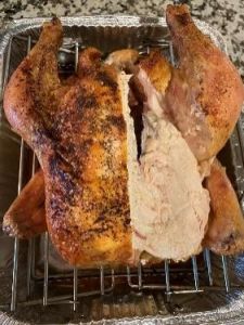 Whole roasted turkey with crispy skin and juicy meat, perfect for holiday celebrations.