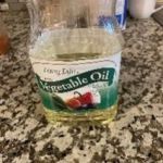 Vegetable oil in a glass jar on a kitchen countertop.