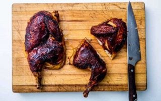 Smoked barbecue ribs on wooden cutting board with chef's knife for grilling and smoking.