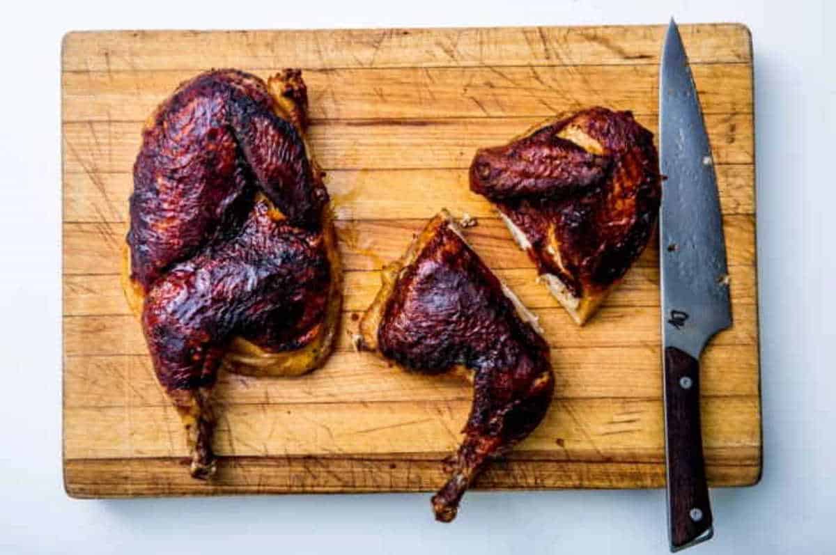 Smoked barbecue ribs on wooden cutting board with chef's knife for grilling and smoking.