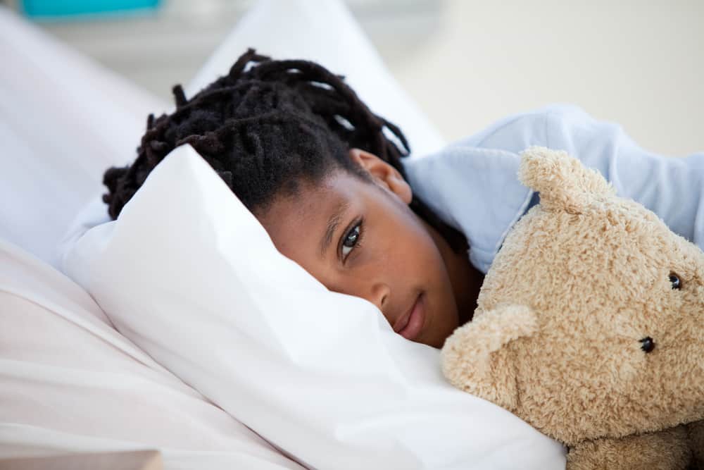 Comfortable child resting with teddy bear for healthy sleep and relaxation.
