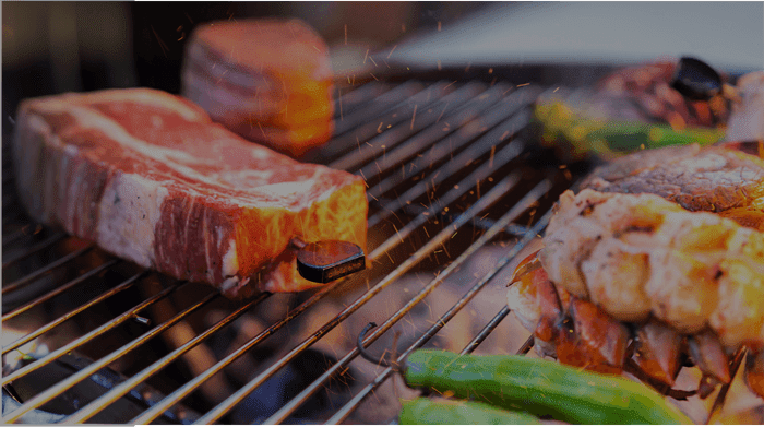 Juicy steak grilling on barbecue grill with vegetables, perfect for home outdoor cooking enthusiasts.