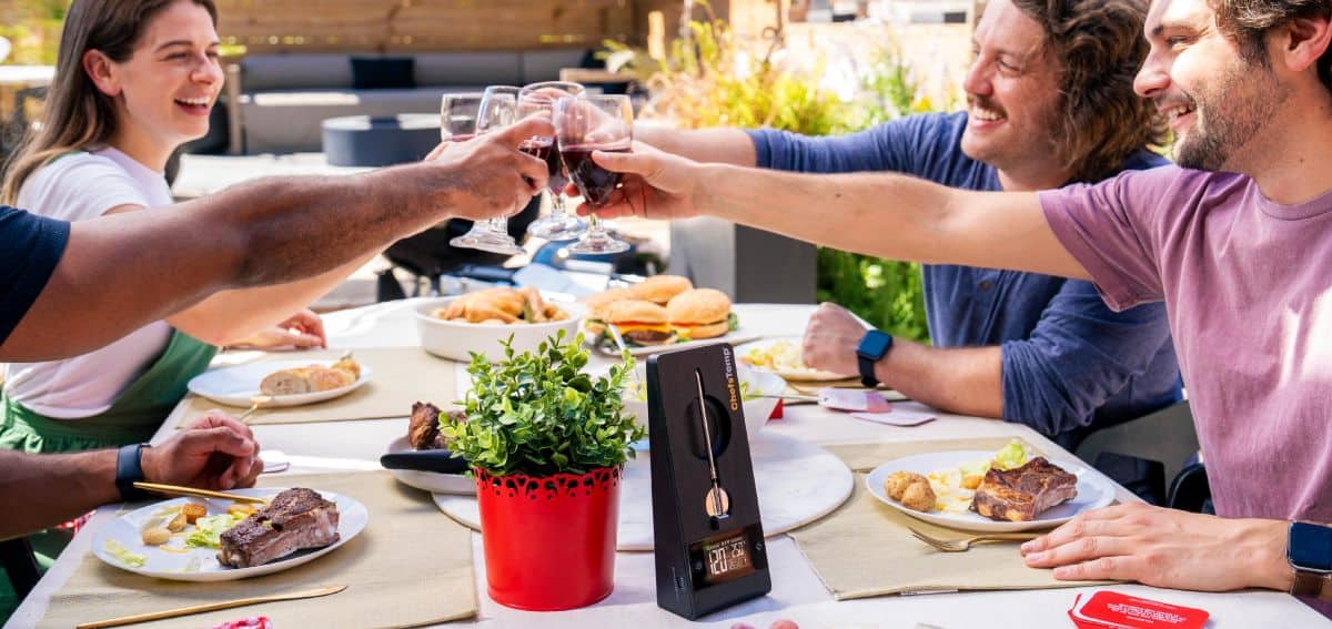 Celebrating outdoors with friends and food, enjoying time and raising glasses for memorable moments.
