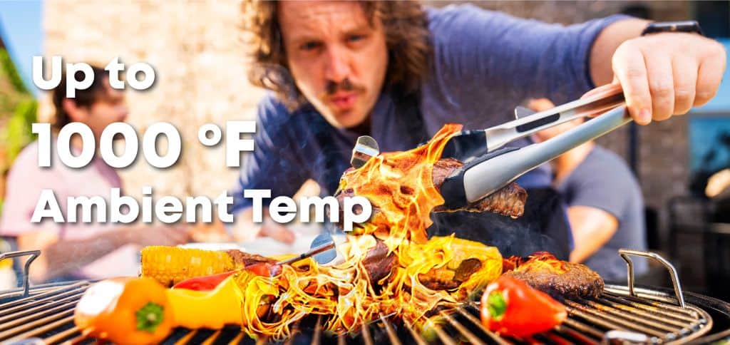 High-temperature grilling with flaming meat and vegetables on outdoor barbecue grill.